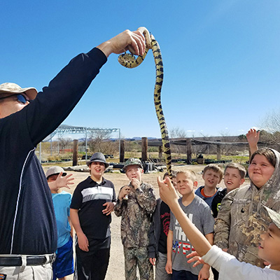 5th graders from Bowler Elementary School interact with snake held by Warm Springs Natural Area biologist.